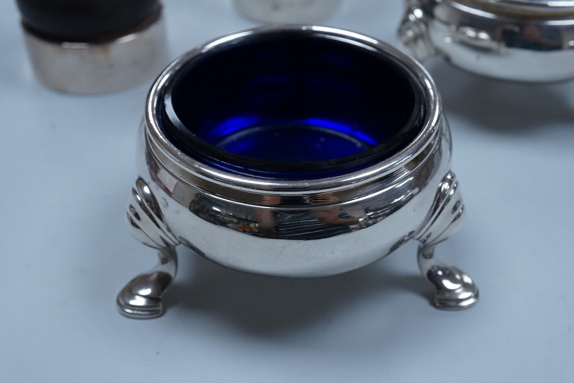 Two modern silver mounted pepper mills, 10.5cm, one other silver pepper mill by Hukin & Heath, Birmingham, 1926 and a pair of George III silver bun shaped salts, David Hennell I, London, 1750, with blue glass liners.